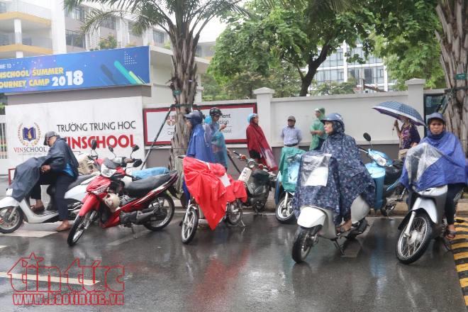 Phụ huynh đứng dưới mưa tầm tã đợi con ảnh 2